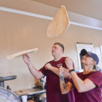 couple throwing pizza dough